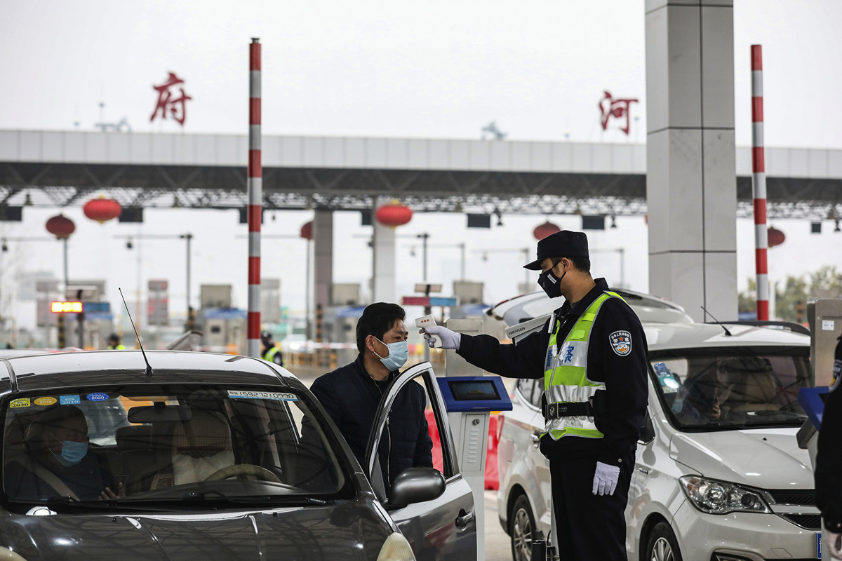 圖為1月24日，一名警察在一條高速公路上檢查一名司機的體溫。（STR / AFP）
