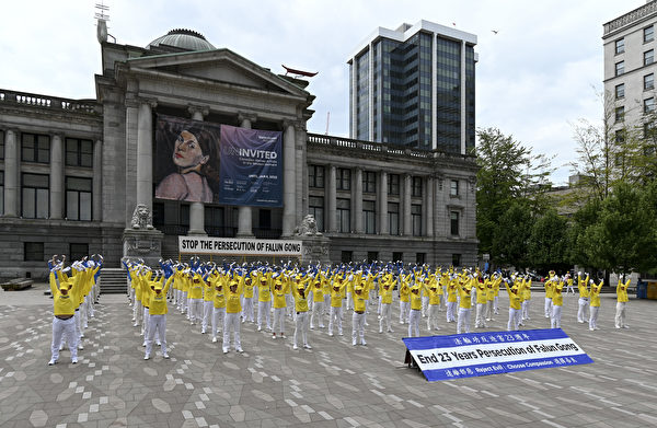 2022年7月9日，部份溫哥華法輪功學員來到溫哥華藝術館北側廣場集體煉功， 祥和的煉功場面吸引路過的遊客駐足觀看。（大宇／大紀元）