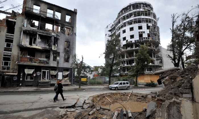 2022年9月18日，在烏克蘭哈爾科夫市中心，有人從被炮擊毀壞的建築前走過。（Sergei Chuzavkov/AFP via Getty Images）