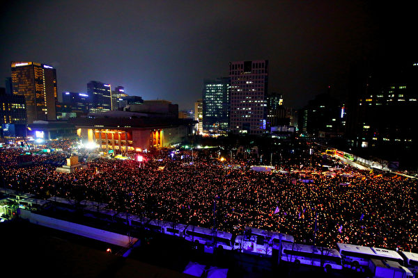 26日晚，冒著凜冽的寒風，南韓民眾在首爾市中心的光華門一帶舉行聲勢浩大的燭光集會遊行敦促朴槿惠在彈劾前自行下台，這是南韓民眾因朴槿惠的“閨蜜干政”醜聞進行的第五次示威,也是其中規模最大的一次。（全景林／大紀元）