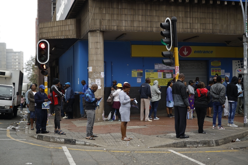 圖為2020年3月28日，南非民眾在一家超市外排隊購物保持間距，以防中共肺炎疫情。（MARCO LONGARI/AFP via Getty Images）