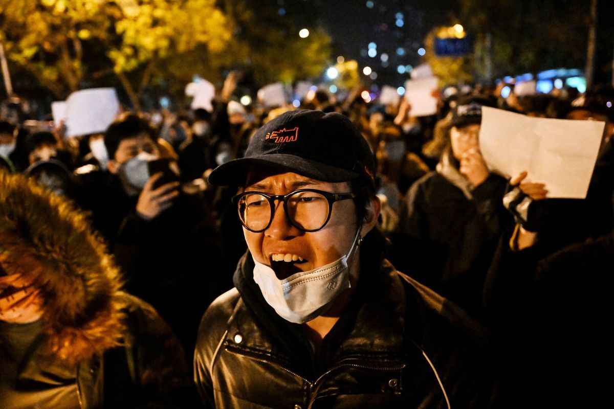 2022年11月28日，在北京，抗議者在為新疆烏魯木齊24日致命火災的受害者舉行的集會上沿街遊行，並抗議中國嚴厲的COVID-19限制。這是公眾對中共憤怒的罕見表現。（Noel Celis/AFP）