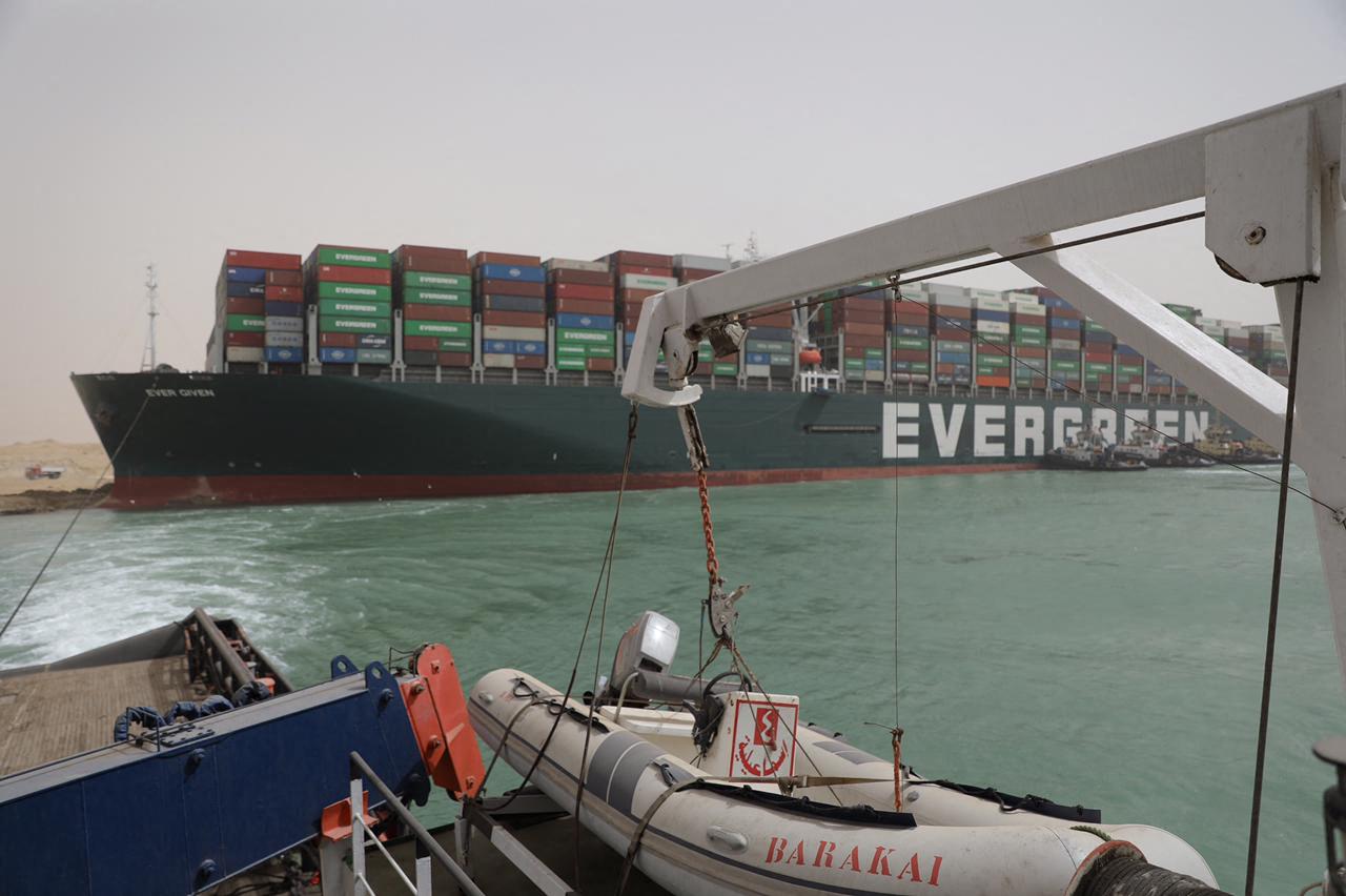 從本周二開始，台灣長榮海運的巨型貨櫃輪「長賜」號（Ever Given，長賜輪）被卡在蘇彜士運河（又譯蘇伊士運河）的南北通航方向。圖為3月25日，一艘拖船試圖營救 「長賜」號。（Suez CANAL/AFP）