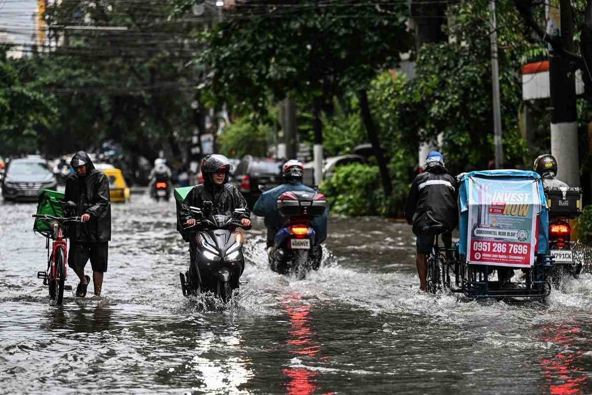 2026年8月17日，在菲律賓首都馬尼拉，多條街道因短時強降雨而嚴重積水，民眾被迫涉水而行。（Jam Sta Rosa/AFP via Getty Images）