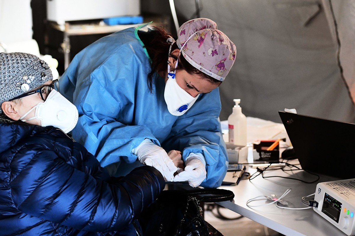 2020年3月4日，意大利醫務人員正在向一名中共肺炎患者提供幫助。（MIGUEL MEDINA/AFP）