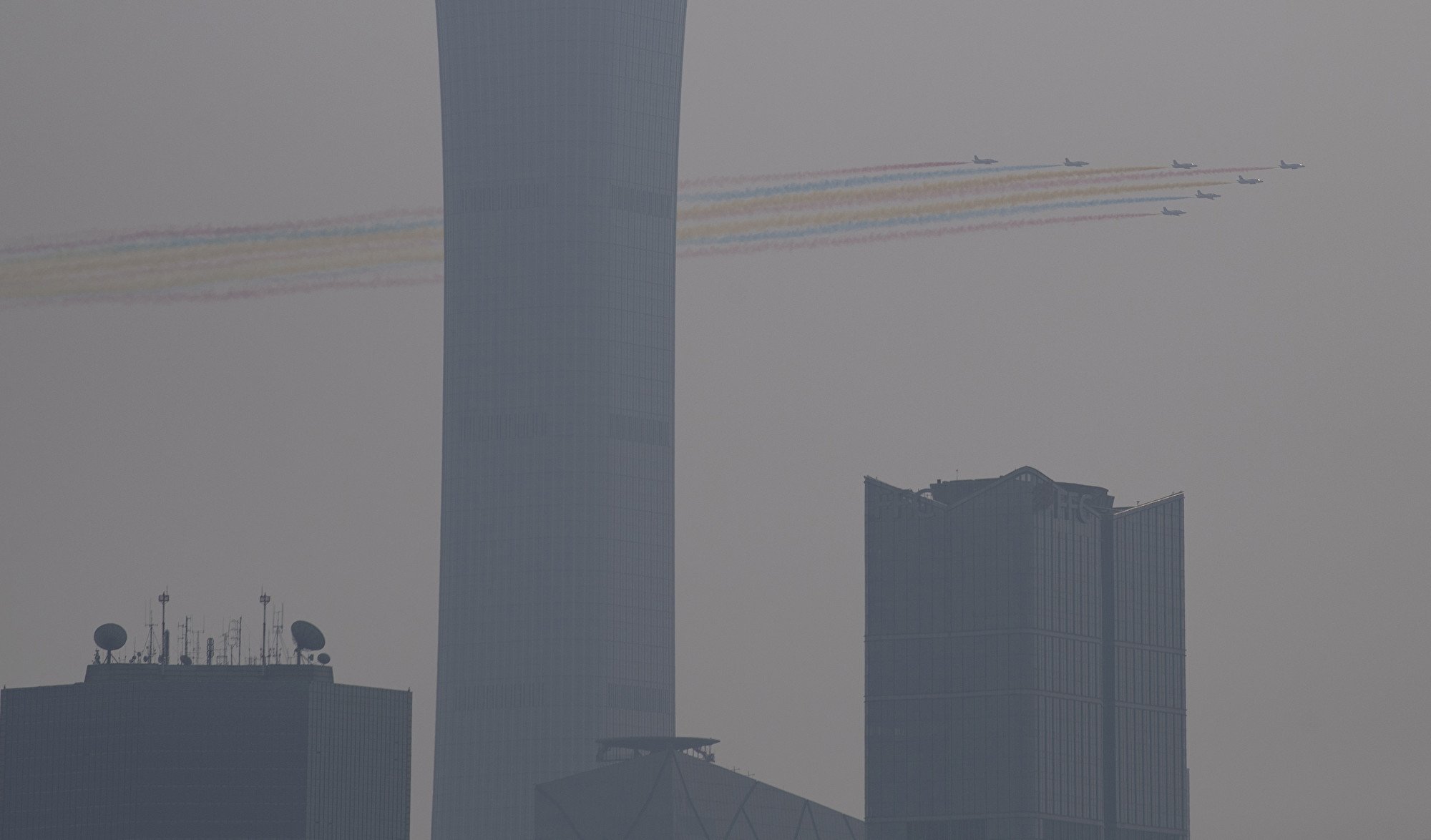 10月1日中共舉行閱兵式，北京城被陰霾籠罩。圖為天空中的彩色飛機陣。（NOEL CELIS / AFP）