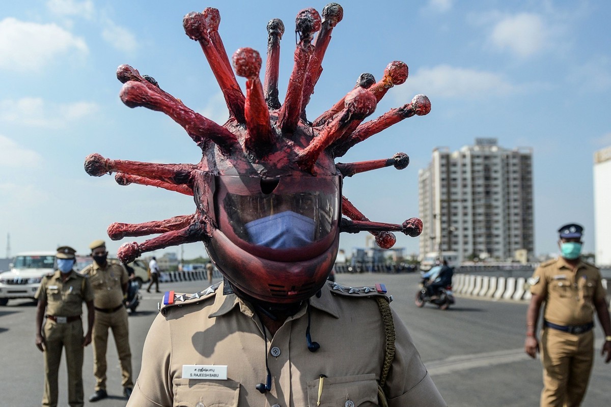  2020年3月28日，印度清奈一名警察戴著病毒狀安全帽，警告民眾待在家裏，不要外出。（ARUN SANKAR/AFP via Getty Images）