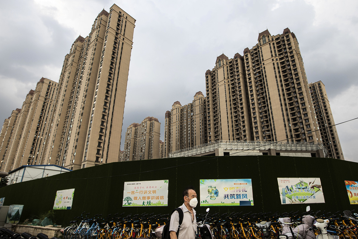 中國房地產商陷入危機，其物業公司也受到連帶。圖為2021年9月24日，一名男子戴著口罩在湖北省武漢市恒大開發的長青社區內行走。（Getty Images）