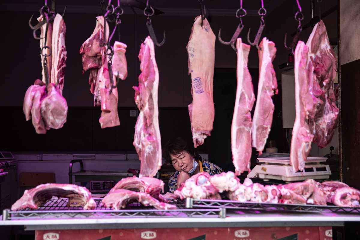中國7月豬肉價格飆漲逾二成，使消費通脹率加速上升至兩年來的最高水平。圖為2022年5月16日，湖北省武漢市一豬肉攤販在打盹。（Getty Images）
