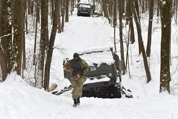 3月7日，烏克蘭第二大城哈爾科夫外的一片森林中，一名烏克蘭士兵走過被摧毀的俄羅斯軍事車輛。 （SERGEY BOBOK/AFP via Getty Images）