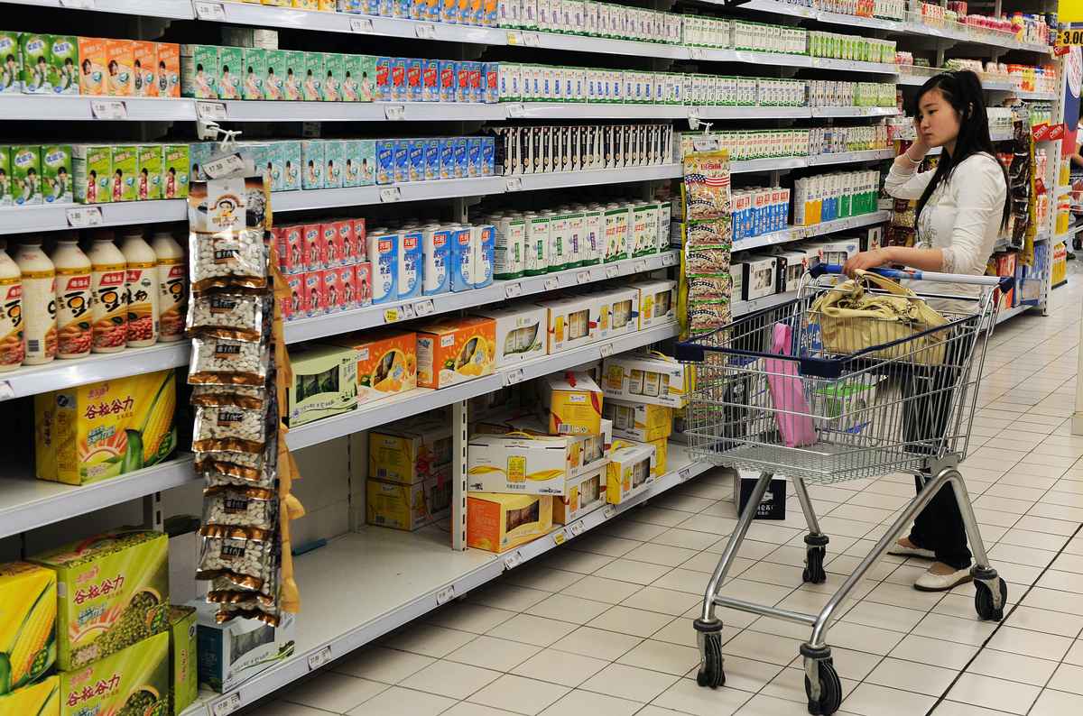 2010年5月11日，安徽省合肥市一位購物者在一家超市查看牛奶的價格。（AFP/AFP via Getty Images）