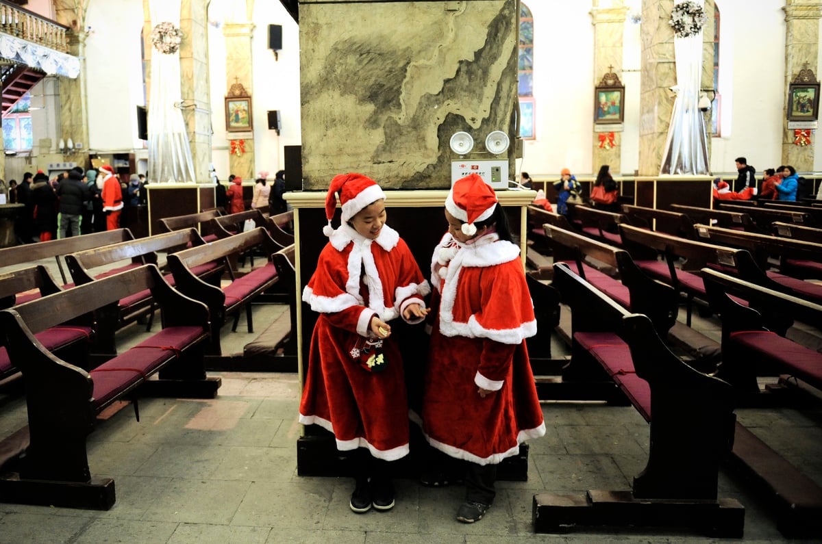 當大半個地球都沉浸在聖誕節的歡樂氣氛中時，中國大陸更多的地方在禁止人們過聖誕節。圖為兩名女孩在2012年平安夜打扮成聖誕老人。 （Wang Zhao/Getty Images）