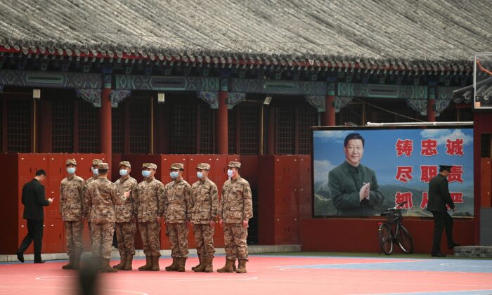 2022年3月11日，全國人民代表大會閉幕會議在北京人民大會堂舉行。警衛的右方是中國領導人習近平的形象。（Noel Celis/AFP via Getty Images）