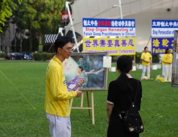 林先生在向路過的民眾介紹法輪功,以及法輪功在中國大陸被迫害的真相。(繩銓/大紀元)