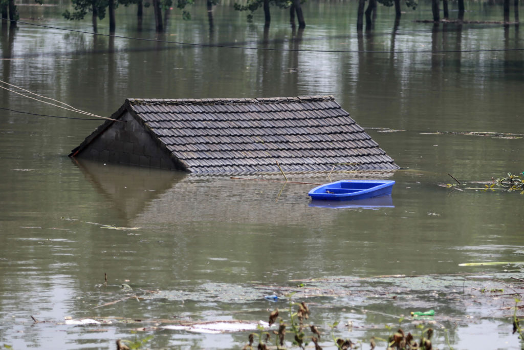 雲南省丘北縣持續強降雨引發多宗險情。圖為江蘇省鎮江市的長江邊，一棟被淹沒的房子的屋頂。（STR/AFP via Getty Images）