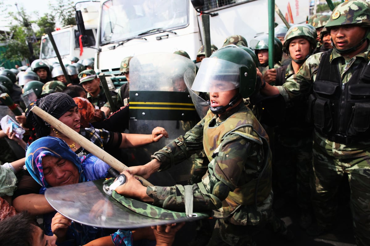 2009年，中共警察在烏魯木齊驅趕和鎮壓維吾爾婦女。（Guang Niu/Getty Images）