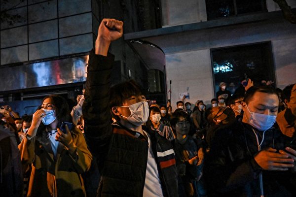 2022年11月27日，人們聚集在香港街道上，高喊口號，進行抗議。（Hector Retamal/AFP）