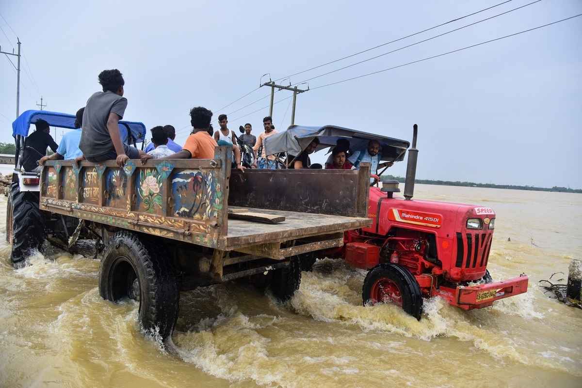 2025年6月3日,印度阿薩姆邦霍賈伊區(Hojai district)發生嚴重洪澇,人們帶著物品,乘坐拖拉機轉移至安全地帶。(Anuwar Hazarika/Middle East Images/AFP via Getty Images)