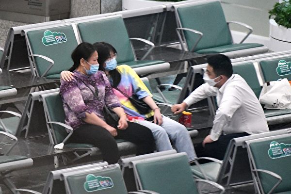 2022年3月21日，東航MU5735航班在飛往廣州的途中，墜毀在廣西省一個山坡上，圖為乘客的親屬坐在廣州白雲國際機場的等候區。（Noel Celis/AFP）