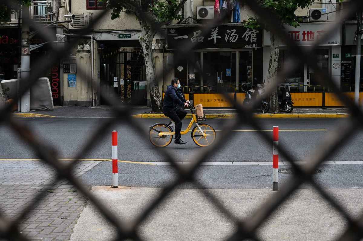 2022年5月19日，上海封鎖期間，一名男子在街道上騎著單車。（Hector RetamaL/AFP via Getty Images）