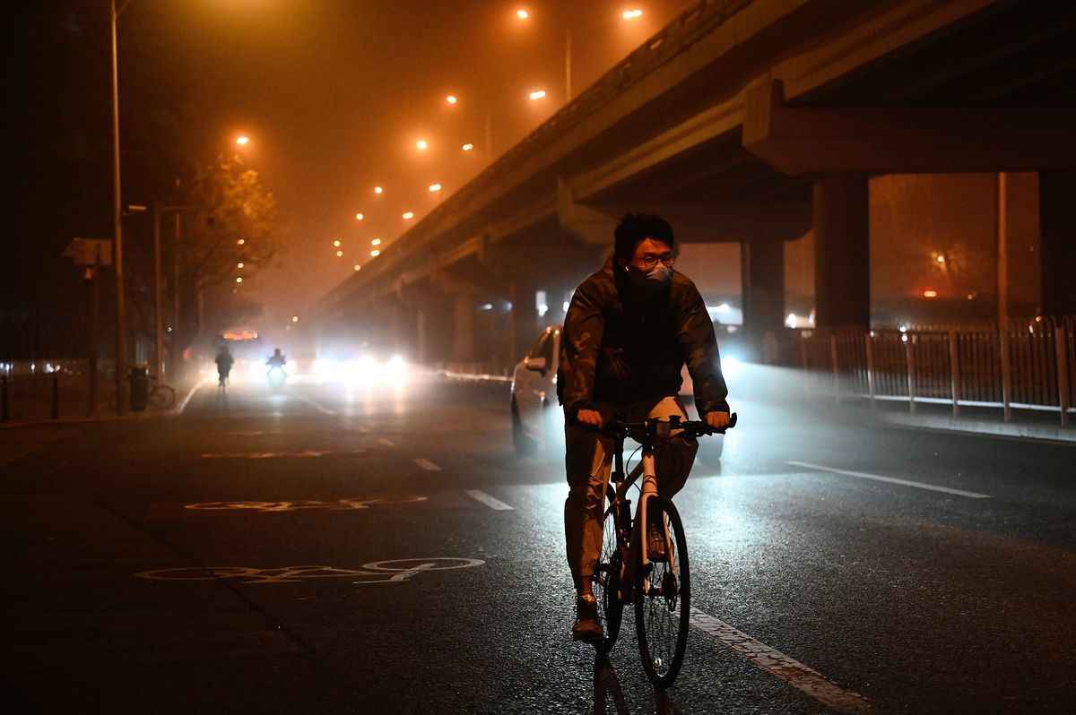 2023年4月10日晚，沙塵暴已抵達北京，市民在路上騎車。（JADE GAO/AFP via Getty Images）
