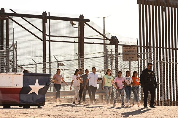 2023年5月11日,在德薩斯州埃爾帕索(El Paso)的美墨邊境,非法移民在沿邊境牆等待向美國海關和邊境保護局的邊境巡邏人員自首,以便跨越格蘭德河進入美國,在完成移民和庇護申請處理後登上貨車。(Patrick T. Fallon/AFP via Getty Images)