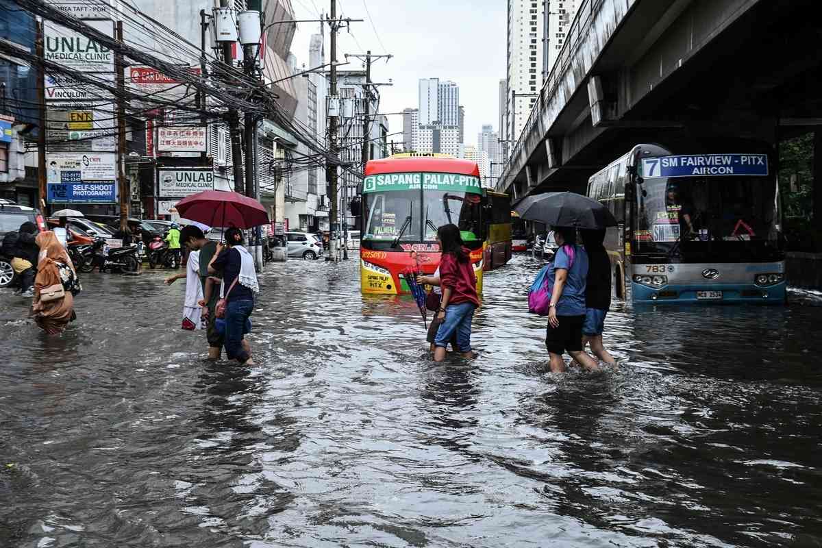 2026年8月17日，在菲律賓首都馬尼拉，多條街道因短時強降雨而嚴重積水，民眾被迫涉水而行。（Ted Aljibe/AFP via Getty Images）