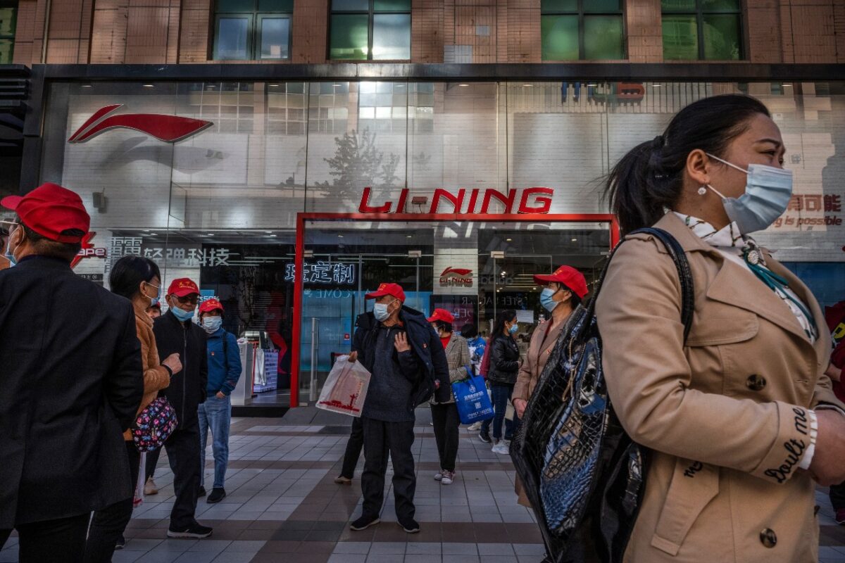 2021年4月16日，在北京的一個購物區，遊客和購物者從中國運動服裝品牌李寧店前走過。（Kevin Frayer/Getty Images）