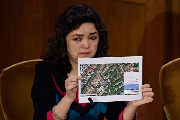 英國民間法庭「維吾爾法庭」2021年6月4日召開第一天的聽證會，維吾爾族教師凱勒比努爾席迪克（Qelbinur Sidik）舉著一張醫院的照片表示，她在那裏目睹被強迫接受絕育手術的女性。（Tolga Akmen/AFP via Getty Images）