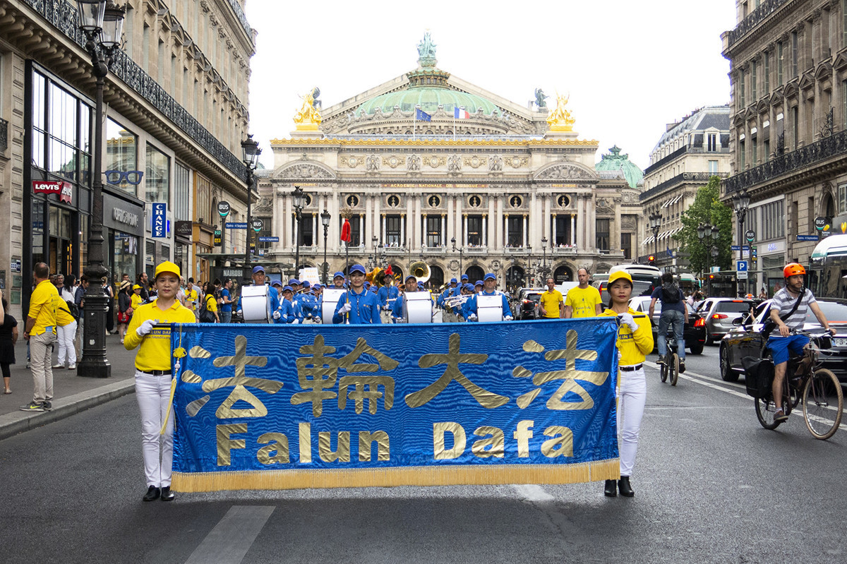 7月20日下午，來自歐洲十幾個國家的部份法輪功學員在法國巴黎舉行「紀念法輪功學員反迫害20周年」大遊行，圖為遊行隊伍途經巴黎歌劇院。（關宇寧／大紀元）