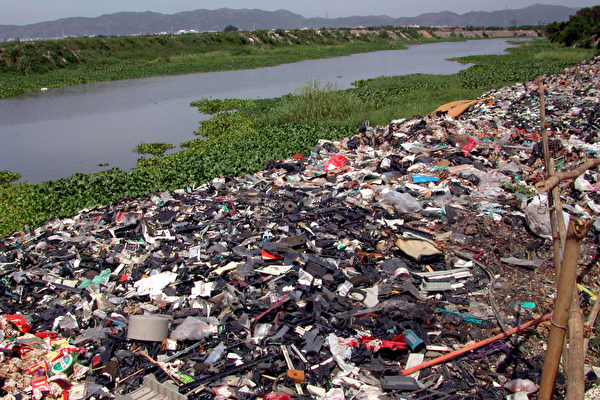 被搾取完全部價值物料的電子垃圾被隨意掉棄在河邊，延綿數百米。（綠色和平提供）