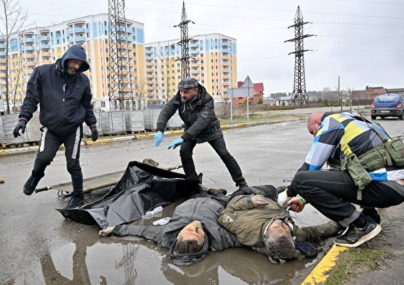 2022年4月3日，烏克蘭布查鎮（Bucha），俄羅斯軍隊屠殺當地居民後撤離基輔。圖為工作人員正在處理兩位鎮民的屍體。（Sergei Supinsky/AFP）