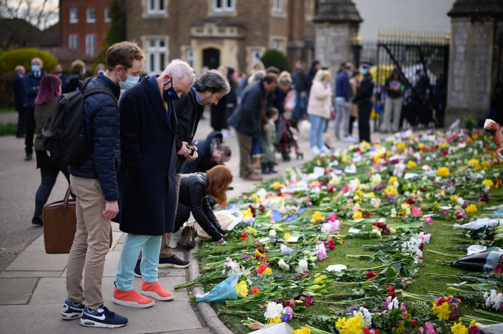 很多民眾在溫莎城堡和白金漢宮門外擺放鮮花，紀念菲臘親王。（Leon Neal/Getty Images）