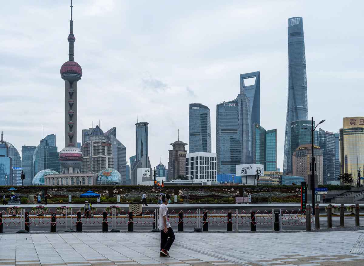 2022年6月10日，一名上海居民在散步，遠處是上海的陸家嘴金融中心。（LIU JIN/AFP via Getty Images）