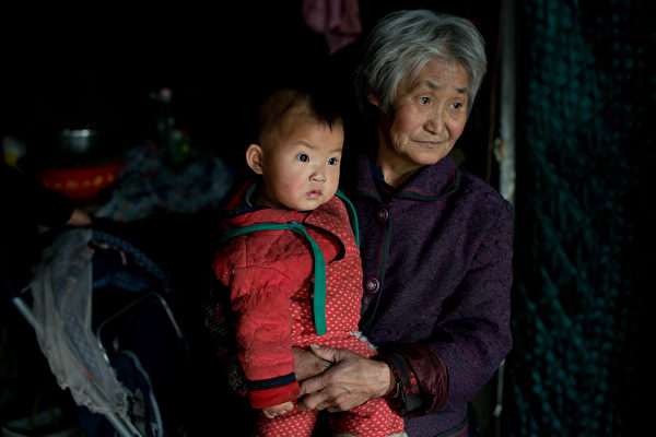 2013年3月21日，一名婦女和她的孫子在河北省承德市家中。（Ed Jones/AFP via Getty Images）