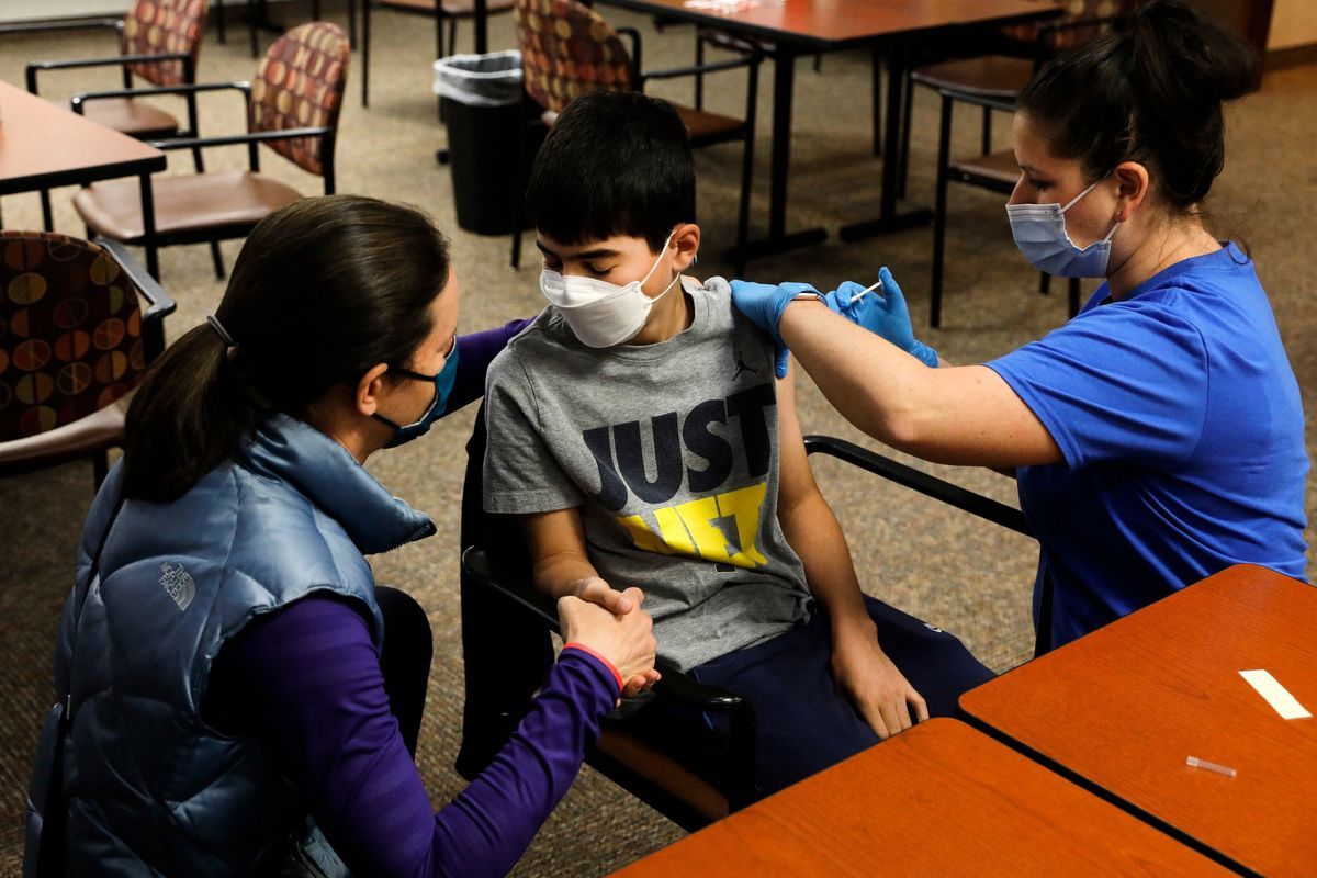 2021年5月13日，密歇根的一位中學生在母親（左）的陪護下接受疫苗注射。（JEFF KOWALSKY/Getty Images）