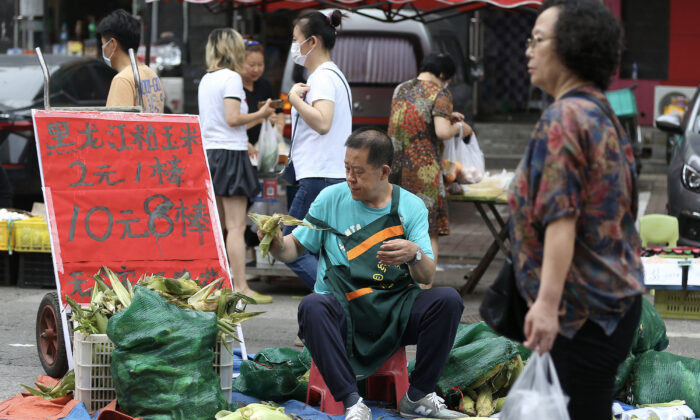 2022年7月9日，中國瀋陽市的一個市場上，一個小販在出售粟米。（STR/AFP via Getty Images）