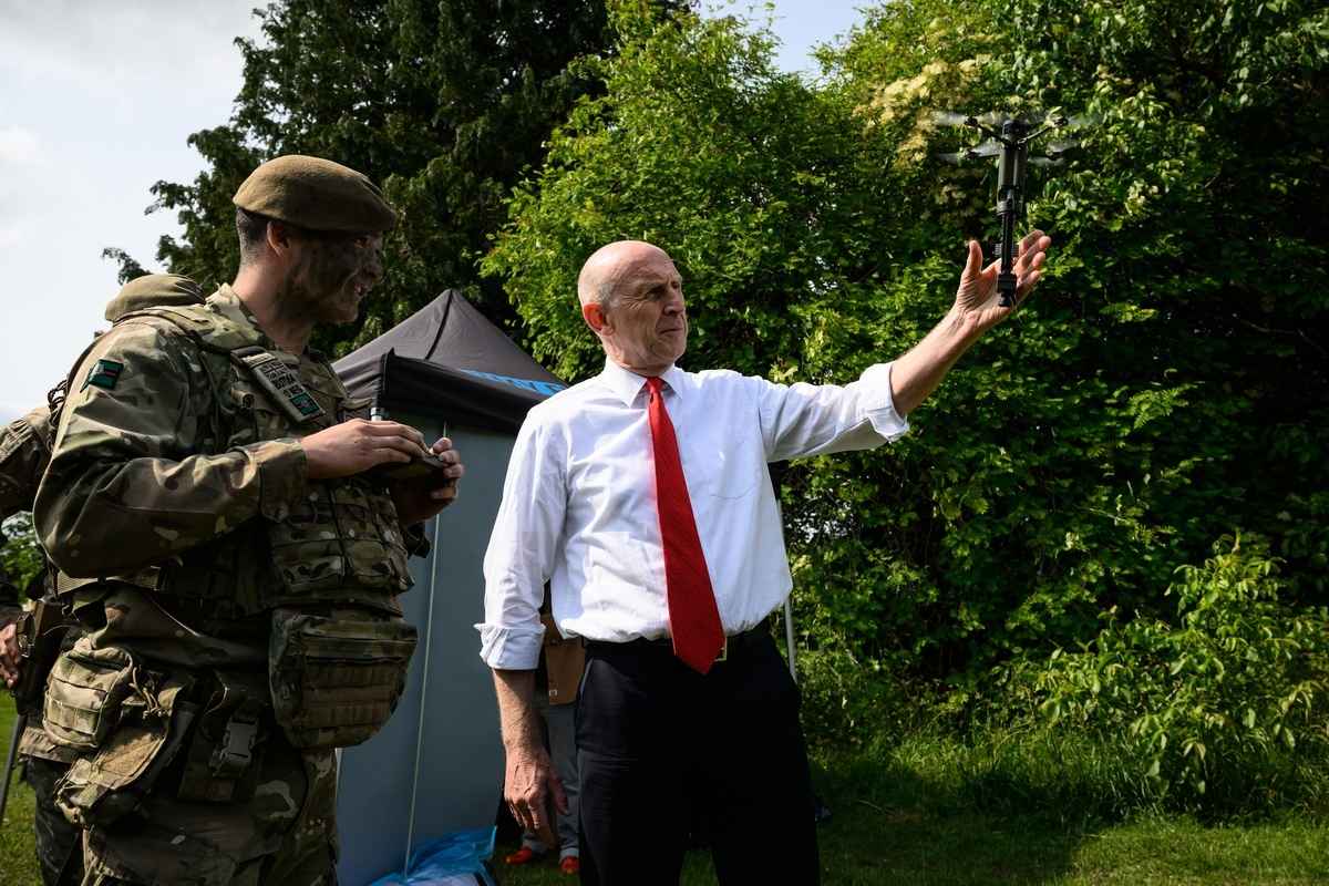 2025年6月3日,英國國防大臣賀理安(John Healey,右)在軍營視察時,手持一架Defendtech D40無人機準備進行起飛展示。英國政府已宣布投入20億英鎊加速本土無人機與自主系統研發,另將撥款10億英鎊發展「龍火」(DragonFire)激光武器,並建立無人機研發中心。 (Leon Neal/Getty Images)