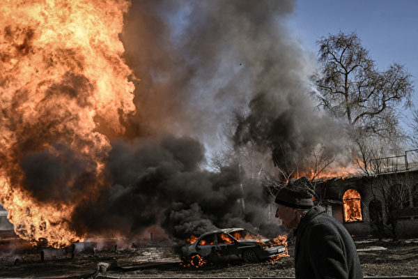 俄軍在烏克蘭戰場的優勢就是火炮數量多，彈藥充足，但是俄軍的火炮射擊精度很差，主要依靠無差別的狂轟濫炸。圖為2022年3月25日，烏克蘭東北部城市哈爾科夫市，遭受俄軍砲火襲擊後，一名烏克蘭婦女走過火焰和濃煙。（Aris Messinis/AFP）