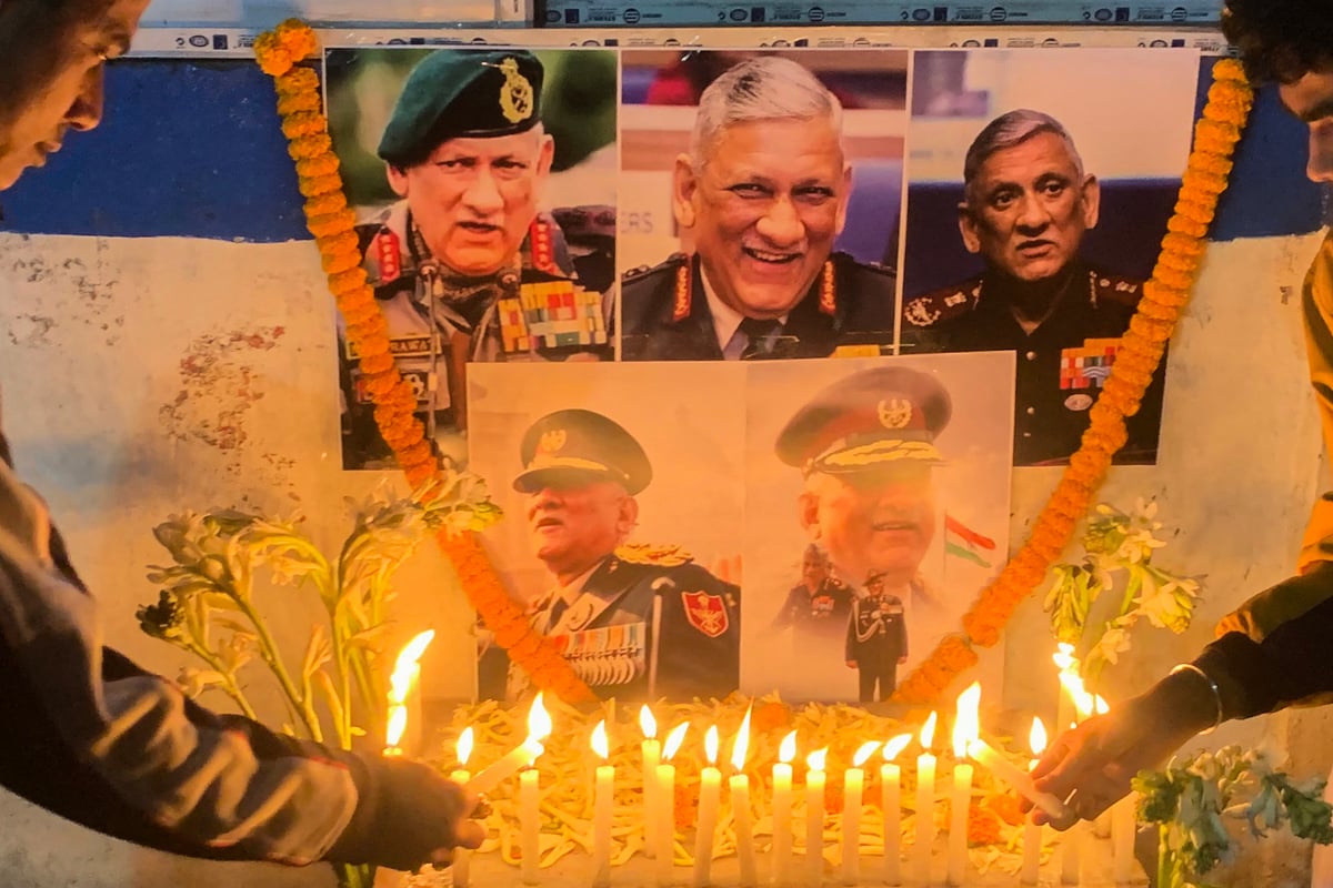 2021年12月8日，在發生空難後，人們在印度國防參謀長Bipin Rawat將軍遺像前點燃蠟燭以表敬意。據報道，在這起直升機墜毀事故中，有13人遇難，包括國防參謀長夫婦。（DIPTENDU DUTTA/AFP via Getty Images）