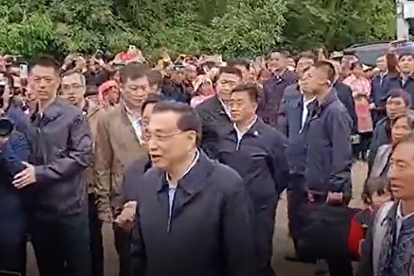 中共國務院總理李克強（中）日前現身雲南，明示經濟下行壓力進一步加大。（影片截圖）
