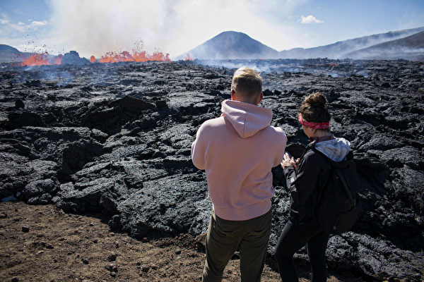 2022年8月4日，冰島法格拉達爾山（Fagradalsfjall）附近，梅拉達利爾（Meradalir）山谷的火山噴發，吸引遊客觀看。（Jeremie Richard/AFP）