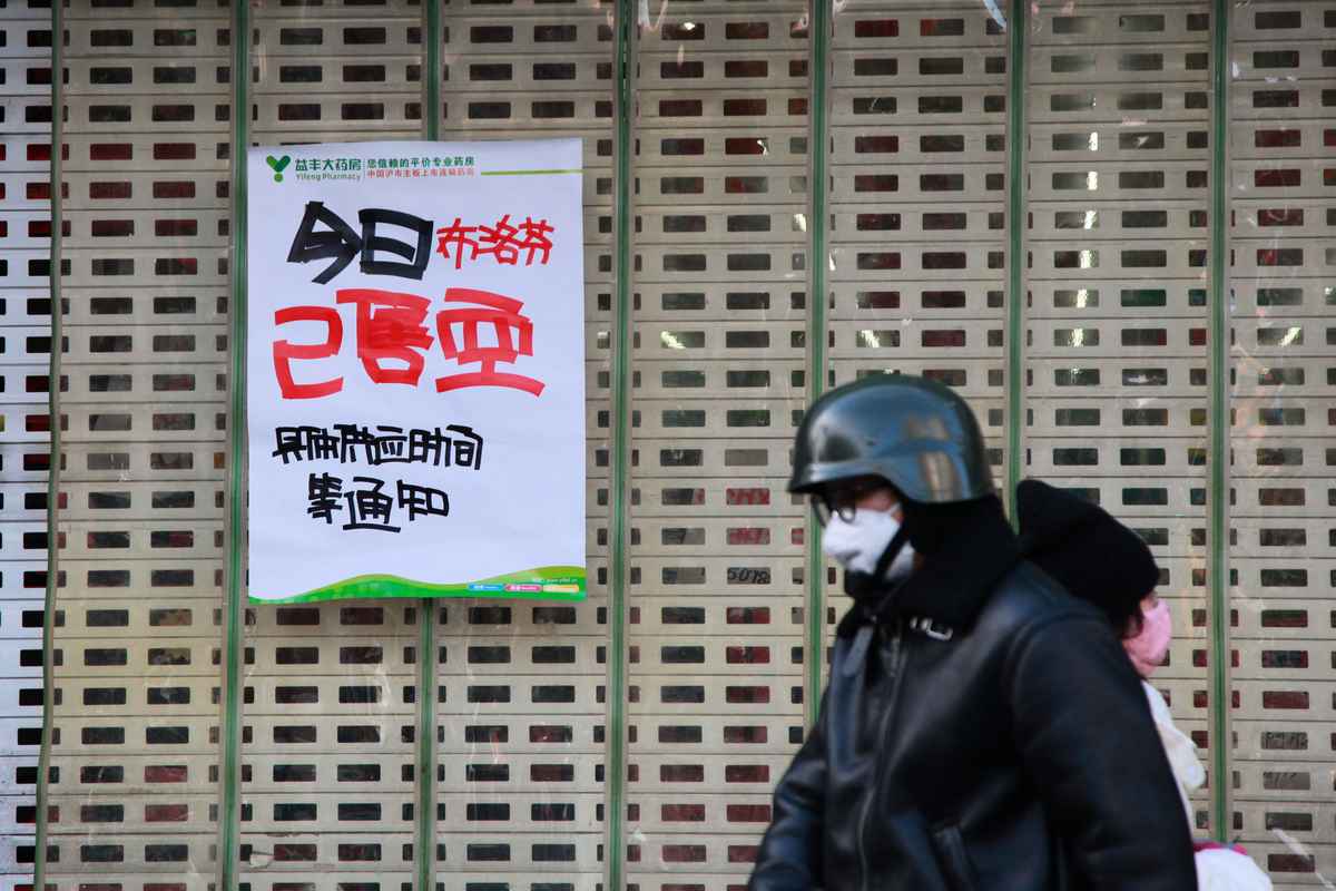 2022年12月20日，江蘇省南京市一名男子走過一張海報，海報上寫著益豐大藥房銷售的布洛芬已經售罄。（STR/AFP via Getty Images）