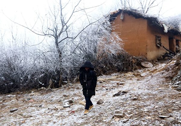 王福滿（又稱「冰花男孩」）在中國西南部雲南省魯甸縣的公路上行走。攝於2018年1月12日。（AFP/Getty Images）