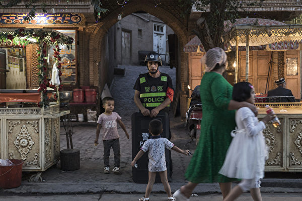中共官員為新疆「再教育營」狡辯被譴責。圖為2017年6月29日，一警察在新疆喀什街頭巡邏。 （ Kevin Frayer/Getty Images）