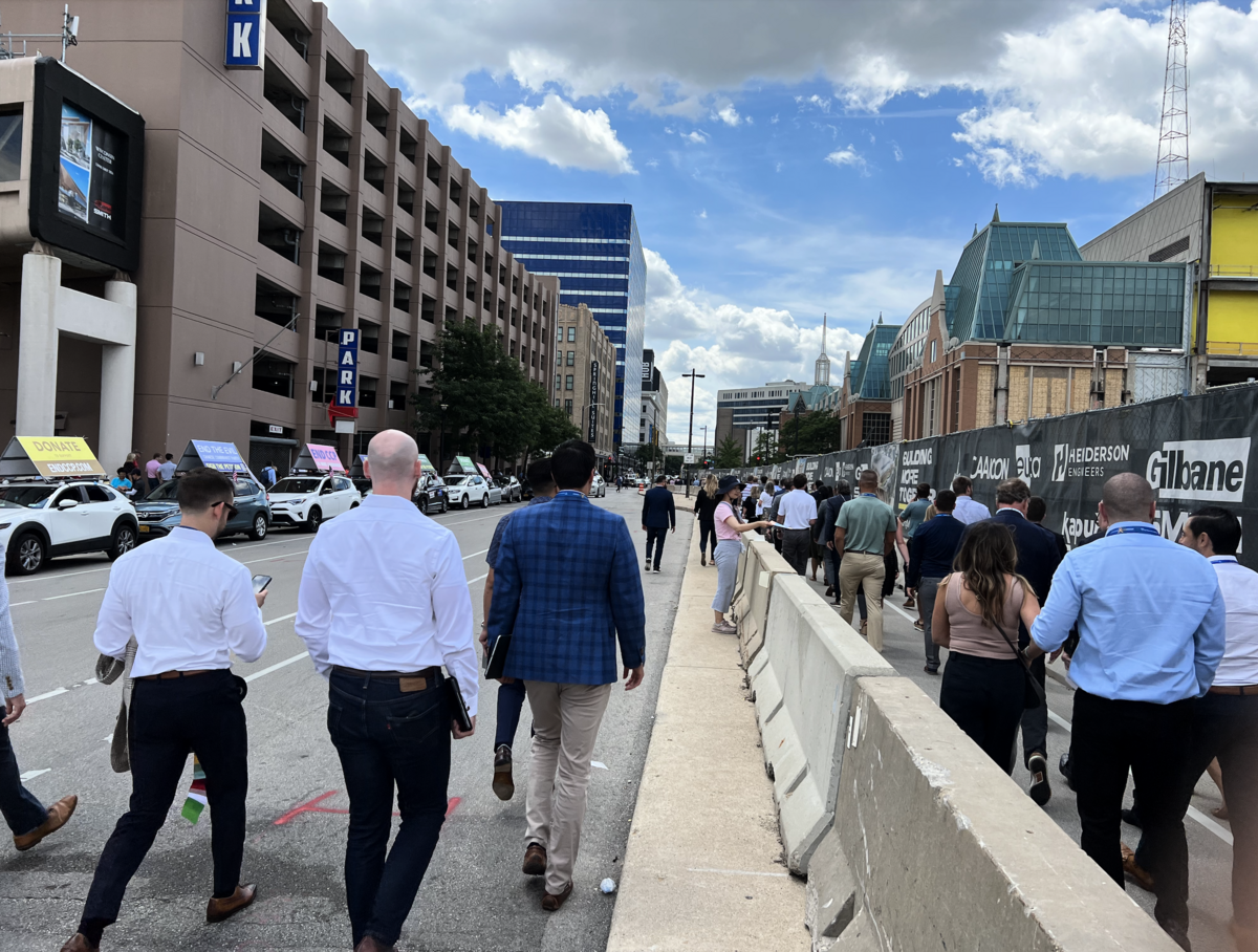7月26日EndCCP車隊在威斯康辛州的密爾華基市遇到一個13000人的會議。圖為會議散場時人們從車隊展板旁路過。（施萍/大紀元）