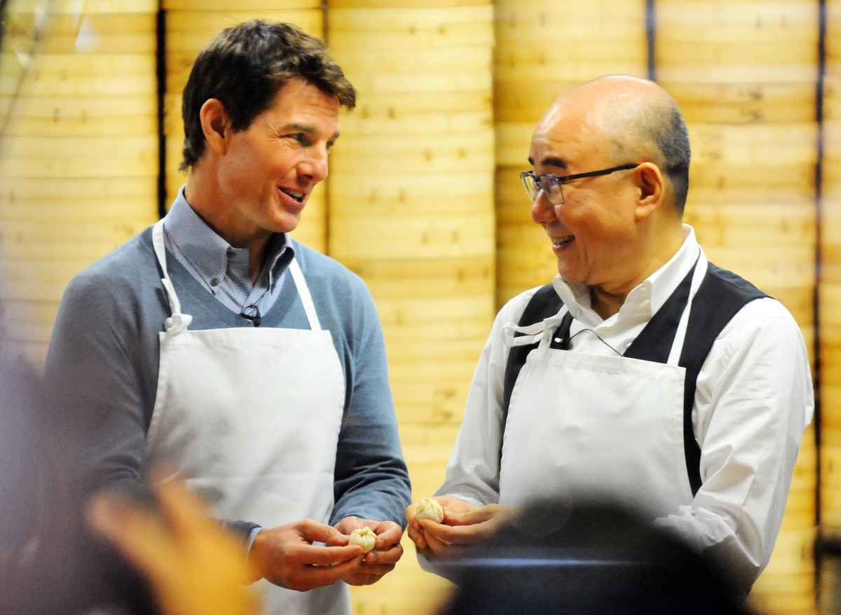 2013年4月6日，美國演員湯告魯斯（左）和台灣鼎泰豐創始人楊秉彞的兒子、老闆楊紀華在台北101大樓餐廳包小籠包。（Mandy Cheng/AFP via Getty Images）