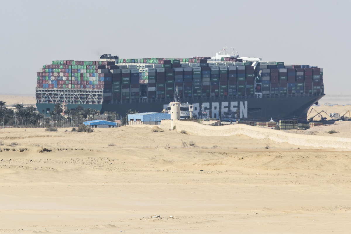 2021年3月28日，蘇伊士運河（埃及段）上的長賜號貨輪。救援工作仍在繼續，這艘巨大的貨櫃船仍擱淺在蘇伊士運河中，挖泥船一直在船的左舷工作，試圖清除沙子和泥漿，使船隻脫困。（Mahmoud Khaled/Getty Images）
