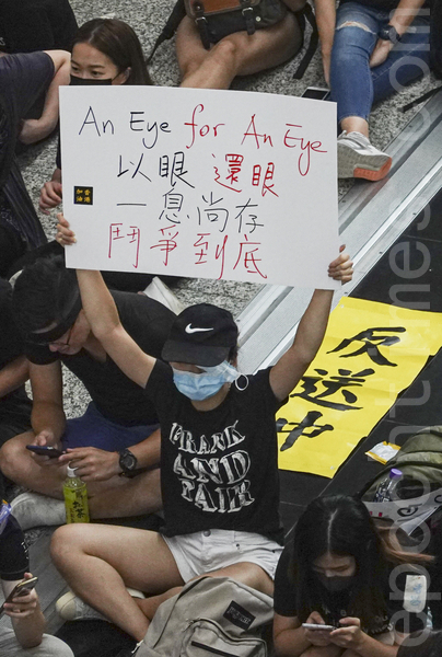 2019年8月12日，針對8.11警察在清場過程中近距離開槍致使一女示威者眼球爆裂，示威者到機場集會，同時高呼「還眼」對警察近距離射殺示威者表達憤怒。（余鋼／大紀元）