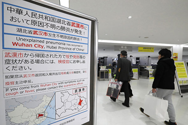 日本成田機場就中共肺炎貼出通知，要求去過武漢的有發燒症狀的遊客主動申告。 (STR/JIJI PRESS/AFP via Getty Images)